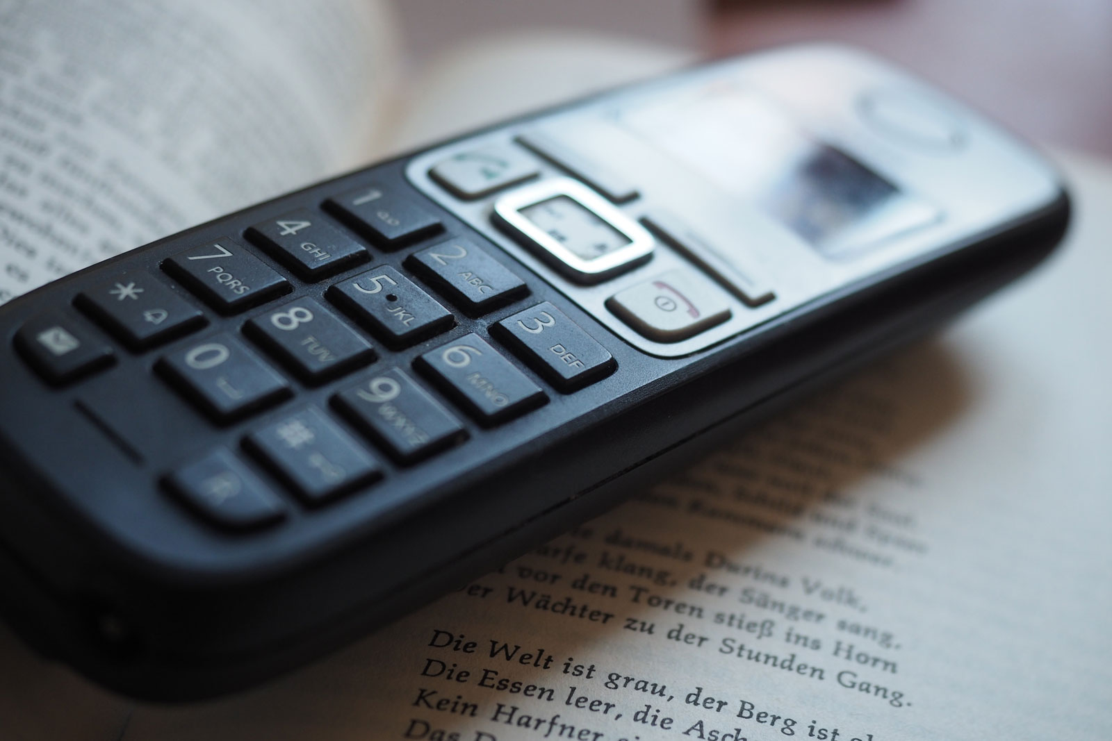 Bild von einem Telefon auf einem aufgeschlagenen Buch