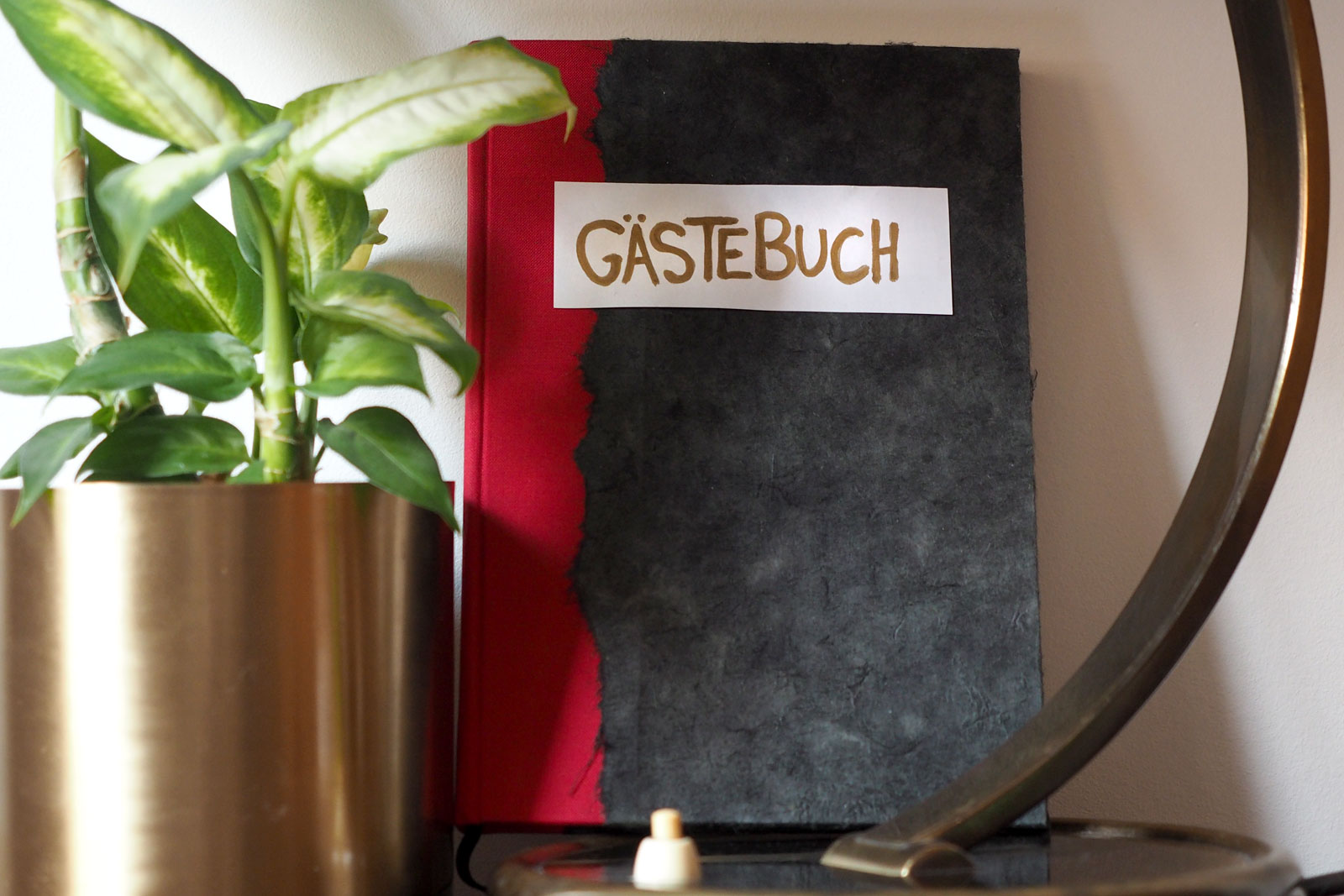 Bild von Gästebuch neben Blume und Lampe