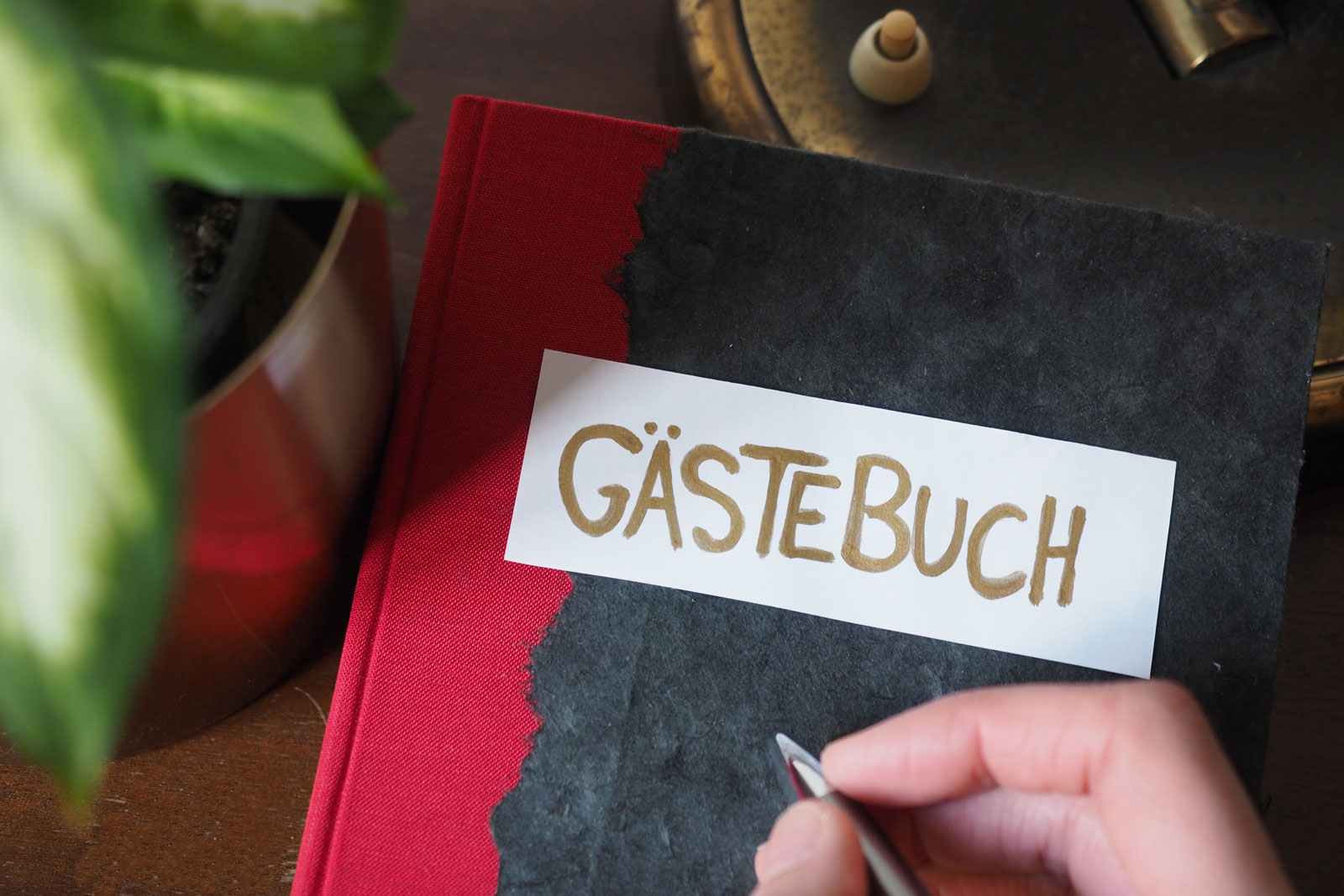 Bild von Gästebuch neben Blume mit Hand