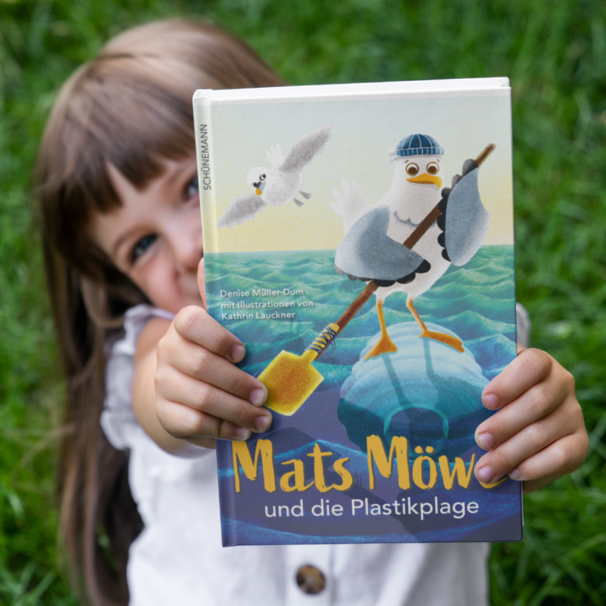 Kind hält Buch in die Kamera