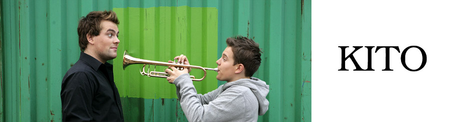 Bild vom Kito, zwei Menschen vor grüner Wand mit Trompete
