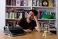 Foto von Fabian Navarro in nachdenklicher Pose vor einem Bücherregal