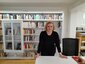 Mila Crespo Pico steht vor einem Regal in der Bibliothek des Instituto Cervantes.