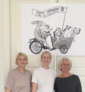 Dr. Alexandra Tacke, Janin Rominger und Heike Müller gratulieren Heidelberg, dabei stehen sie vor Anke Bärs Bild der Bremer Stadtmusikanten.