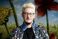 Linus Giese in einer bunten Jacke vor einem bunten Hintergrund