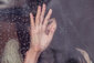 Hand an nasser Fensterscheibe