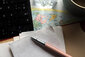 Ein Stift und Papier liegen auf einer Weltkarte.